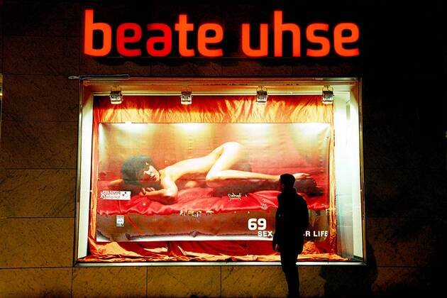 Mann bestaunt nackte Frau auf einem Beate Uhse Werbeplakat am Kurfürstendamm in Berlin