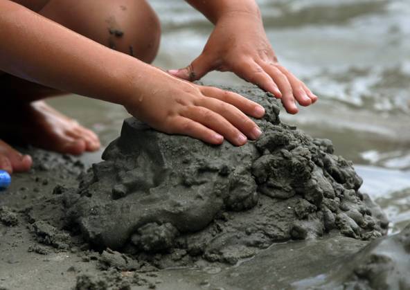 Kleines Kind buddelt am Strand von Kamenjak