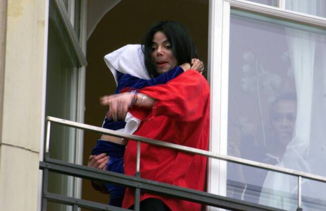 Sänger Michael Jackson präsentiert den angereisten Fans über der Fensterbrüstung des Hotels Adlon in Berlin sein Baby