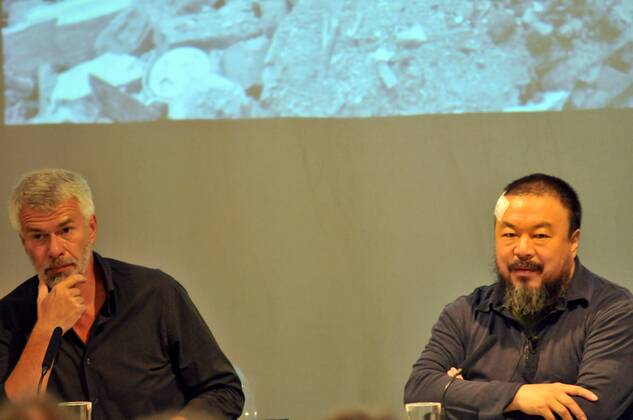 Pressekonferenz anlässlich der Installation, 100m lang x 10m hoch, aus 9000 verschiedenfarbigen Kinderrucksäcken an der Fassade des Hauses der Kunst München. Die chinesischen Schriftzeichen ergeben den Satz: Sieben Jahre lang lebte sie glücklich in dieser Welt, und erinnert an die Tausende durch das Erbeben am 12 Mai 2008 verschütteten Schulkinder. Gesprächspartner, rechts der Künstler AI WEIWEI, links der Direktor des Hauses der Kunst München CHRIS DERCON. Pressekonferenz zur Installation REMEMBERING