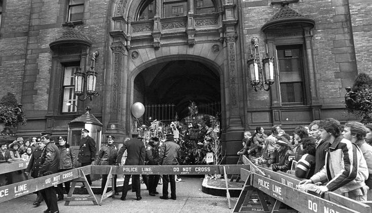John Lennon was shot down outside his home - Dakota House - in New York mourners gathered outside the home in honor and leave flowers  - KP031002