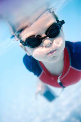 Portrait of cute 6 years old boy swimming underwater - McPSHA