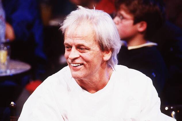 Klaus Kinski (Schauspieler) 10 85 brüg Mann TV Fernsehen Schauspiel Film Kino grauhaarig leger Shirt weiß sitzend Publikum Zuschauer Portrait quer lächelnd