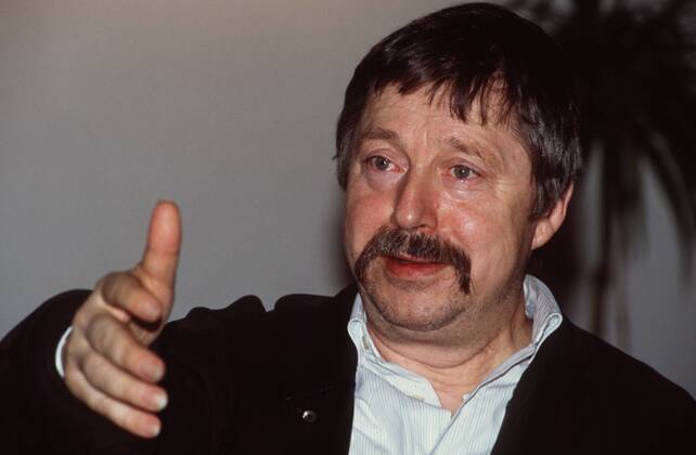 Wolf Biermann (Liedermacher, Autor) 02 92 az Mann Musik Liedermacher Gesang Politik Autor Schnäuzer dunkelhaarig kurzhaarig leger Portrait quer Hand lächelnd Gestik