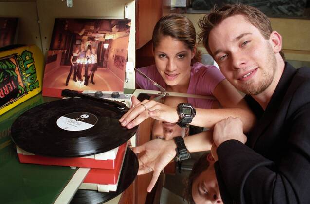 Jasmin Gerat mit Christian Ulmen (Schauspieler Moderation) 05 98 her TV Fernsehen Moderation Musik VJ Videojockey Pop Techno MTV Film Fernsehen Kino Schauspiel Minirock Turnschuhe Sneaker Adidas dunkelhaarig leger sitzend Sofa quer Querformat Blick in Kamera Portrait Porträt Plattenspieler Schallplatte Spiegel lächelnd