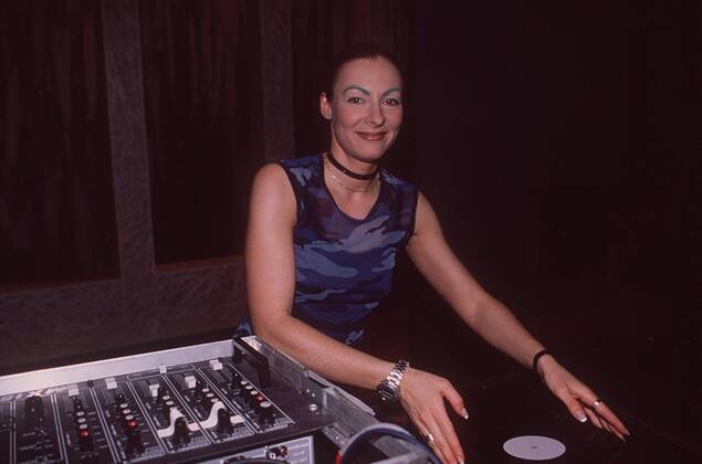 Marusha (Diskjockey) 05 98 her Musik Pop Techno DJ Frau leger langhaarig Diskjockey Pferdeschwanz leger Shirt Schmuck Halsband Augenbraue grün stehend Mischpult Apparat halb quer lächelnd