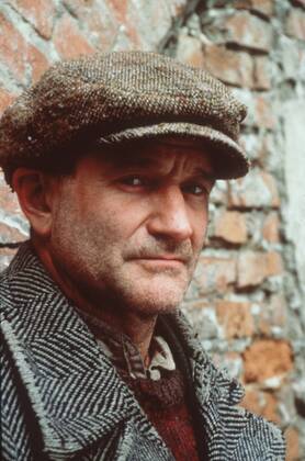Robin Williams in Jakob der Lügner 08 99 teu Mann USA Amerika dunkelhaarig Schauspiel Kino Film Szene Filmszene Verkleidung Kostüm Mantel Fischgrätmuster Hemd alt Pullunder Baskenmütze stehend draußen Mauer Backstein kaputt Dreitagebart Portrait hoch ratlos traurig müde
