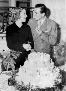 Fred Perry (the British tennis champion) and his bride Miss Helen Vinson (the film actress) were welcomed to Hollywood after their New York wedding with a surprise party in celebration of Miss Vinson s birthday Photo shows Fred Perry tasting the birthday cake cut by his bride Helen Vinson 26th September 1935  UnitedArchives00954275