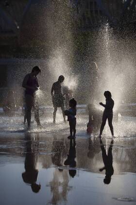 People enjoy in a font on the Manzanares riverside. After of a rare cold weather finally arrived the heat to Madrid city. Spain.