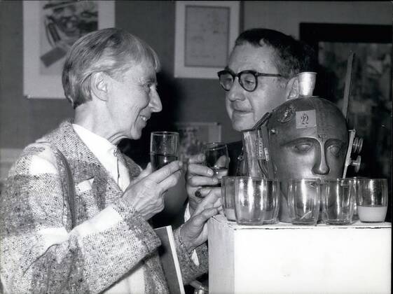 Sep. 09, 1958 - Dada-Exhibition in D&uuml;sseldorf The greatest Dada-Exhibition in Germany after the war begins on Friday, Sept. 5th in the nail of Arts in D&uuml;sseldorf. OPS: Man Ray from New York and Hanna Hoech from Berlin during the press-reception. They have a drink at the exhibition-piece No. 398 the mechanic head  - ZUMAk09