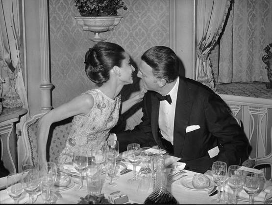 Dec. 22, 1964 - Paris, France - Actress AUDREY HEPBURN whispers to fashion designer HUBERT de GIVENCHY during a reception prior to the premiere of Hepburn s latest film, My Fair Lady. Paris France  - ZUMAk09