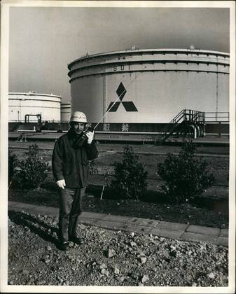 Apr. 04, 1979 - Mitsubishi Oil Co. Kawasaki Refinery, Kawasaki Japan: The Kawasaki Refinery Stores its crude oil on Ohgishima Island where they have hour 94,000 kiloleter product storage tanks, Photo shows A Mitsubishi security employee in fron of one of the large crude oil storage tanks on ohgishima island. - ZUMAk09