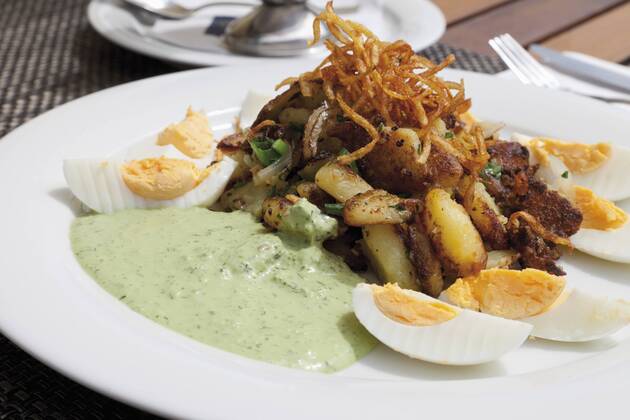 Close up of hard boiled eggs with roasted potatoes, onions and Frankfurter Sauce  CSF015126