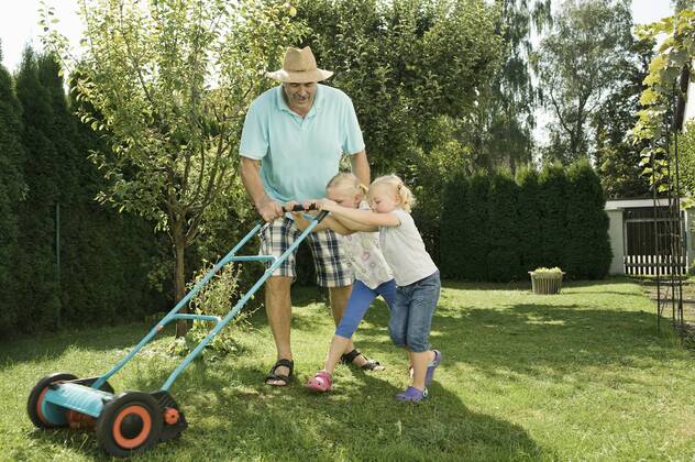 Germany, Bavaria, Grandfather with children mowing lawn model released property released  RNF001004