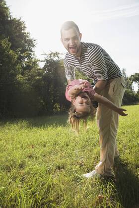 Father playing with his little daughter on a meadow model released Symbolfoto  UUF001521