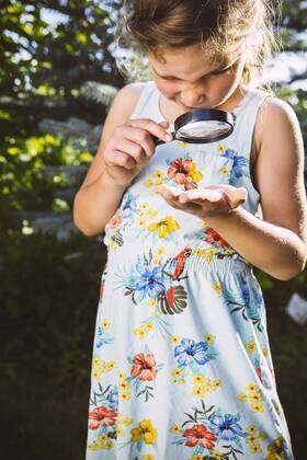Germany, Northrhine Westphalia, Bornheim, Girl examining snail with magnifying glass model released Symbolfoto property released  MFF001214