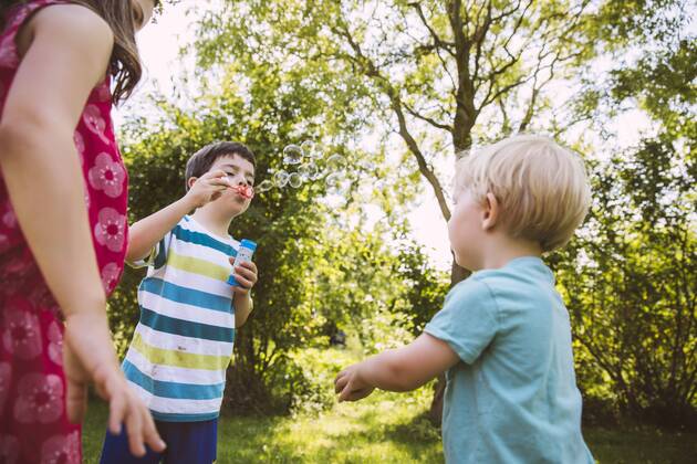 Children blowing soap bubbbles in garden model released Symbolfoto property released  MFF001277