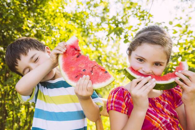 Children eating slices of watermelon in garden model released Symbolfoto property released  MFF001285