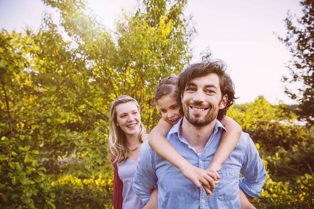 Happy family of three in garden at sunset model released Symbolfoto property released  MFF001322