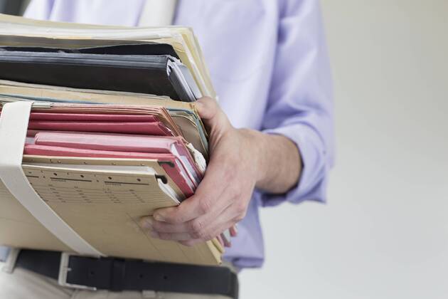 Businessman holding stack of files in office, close up mit_2002_01585