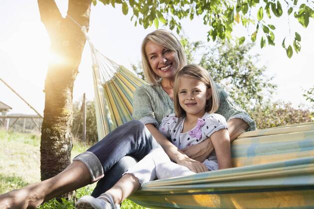 Happy mother and daughter sitting in hammock model released Symbolfoto  RBF001963