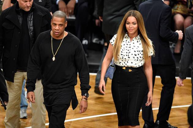Jay Z and Beyonce walk back to their seats after greeting Brooklyn Nets play the Cleveland Cavaliers at Barclays Center in New York City on December 8, 2014.  NYP20141209121