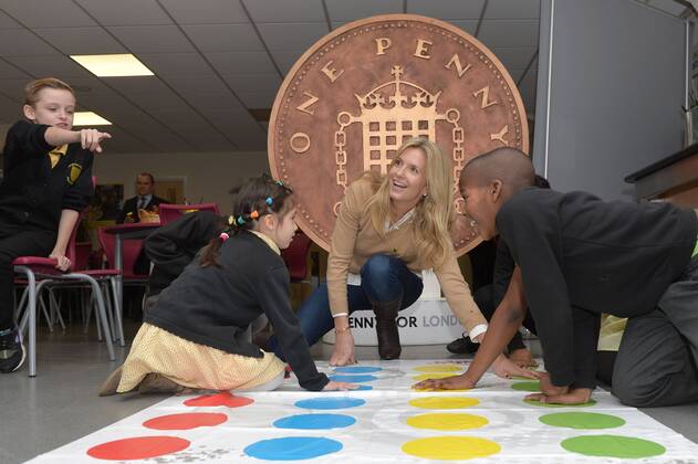 . 18 12 2014. London, United Kingdom. Penny Lancaster visits Charlton Manor Primary School where the Mayors Fund initiative Penny for London is raising money to fund breakfasts for school children. Penny Lancaster plays Twister with children at breakfast club.  xBenxStevensx xi-Imagesx IIM-3778-0002