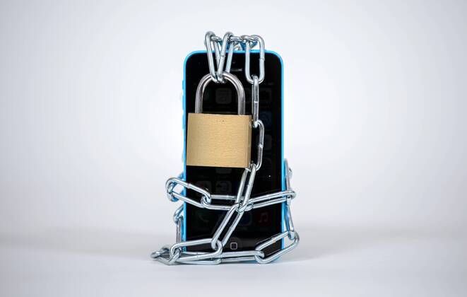 Ein Smartphone wird von einer Eisenkette samt Schloss umschlossen, aufgenommen am 27.01.2015.