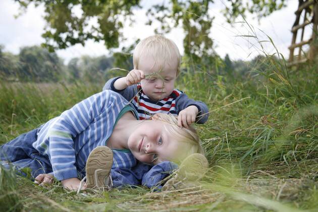 Two little brothers on a meadow model released Symbolfoto  RB002253