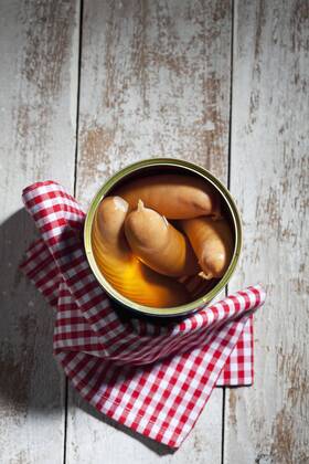 Preserve can of sausages and cloth on wood  CSF024982