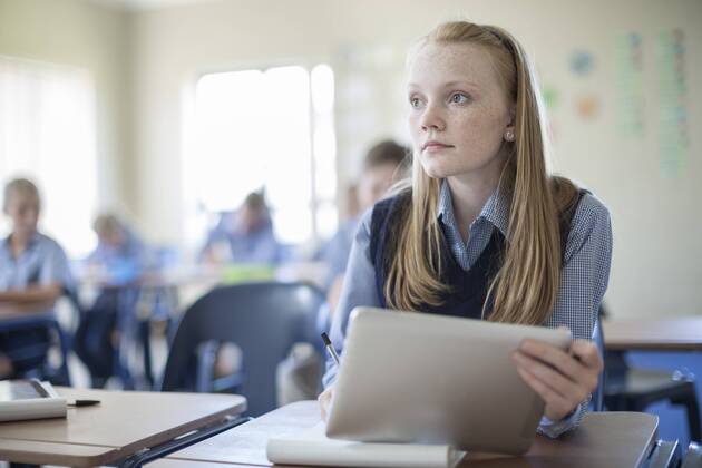 Schoolgirl in classroom with digital tablet model released Symbolfoto property released  ZEF004962