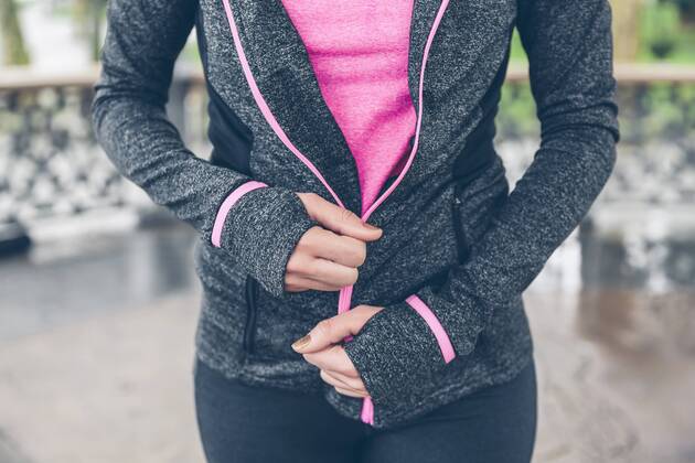Woman closing zipper of sportive jacket model released Symbolfoto  DAPF000038