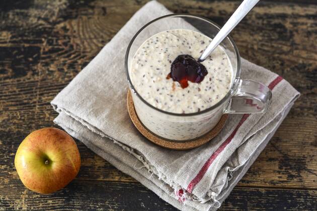 Glass of porridge with jam, linseed and chia seed and an apple on wood  ODF001422