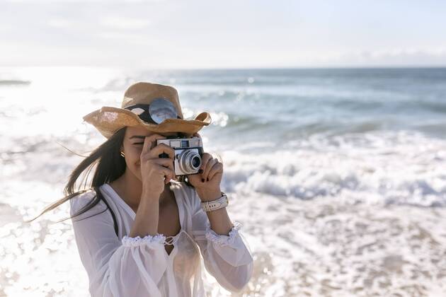 Youniverse - Young Holidays Asturias, Spain, beautiful young woman with a camera on the beach model released Symbolfoto  MGOF002206