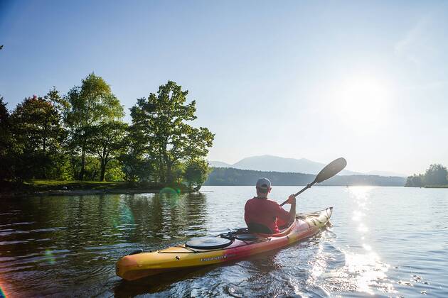Mit dem Kajak unterwegs an einem sonnigen Herbsttag auf dem Staffelsee (Oberbayern), Bayern, Deutschland. Thomas auf einer Kajaktour auf dem Staffelsee (Oberbayern)