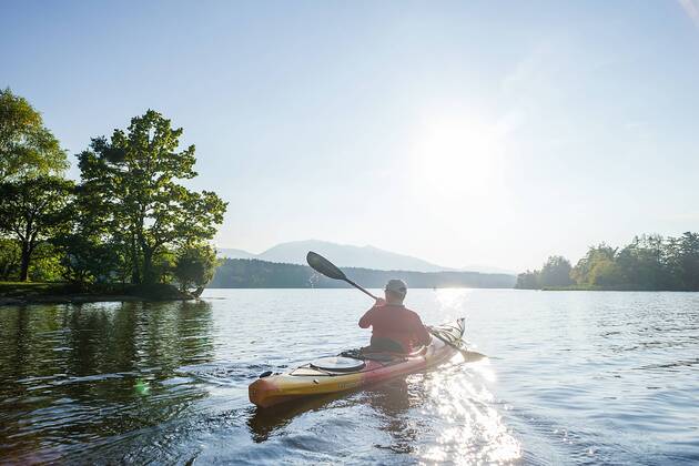 Mit dem Kajak unterwegs an einem sonnigen Herbsttag auf dem Staffelsee (Oberbayern), Bayern, Deutschland. Thomas auf einer Kajaktour auf dem Staffelsee (Oberbayern)