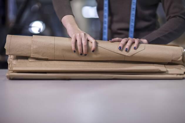 Fashion designer folding up sheet samples in clothing factory model released Symbolfoto property released  ZEF10523