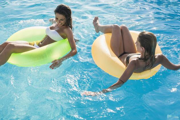 Two young women floating on water in swimming pool model released Symbolfoto  MAUF00900