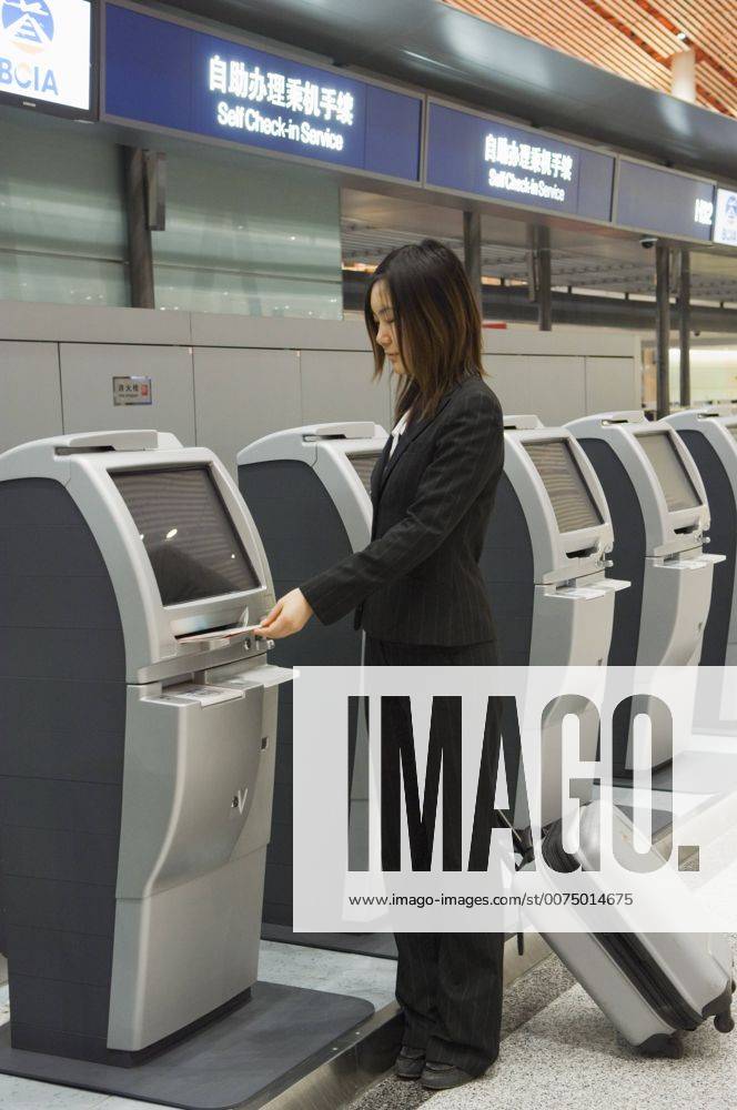 A Chinese business woman using the self service check in machines at ...