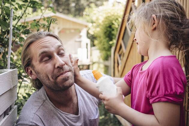 IMAGO Creative, Jahreszeit Sommer, Sonnenschutz Daughter applying sunscreen on father s face in garden model released Symbolfoto property released  JOSF00585