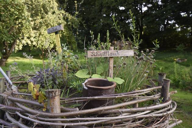 Die Hochbeete im Garten sind mit Ästen aus dem eigenen Wäldchen entstanden. Liebevoll sind die einzelnen Kräuter beschriftet.