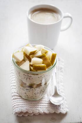 Glass of overnight oats with chia seeds, almond milk and pears  EVGF03197