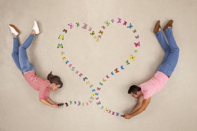 Man and woman sending love messages from smart phone model released Symbolfoto  BAEF01308