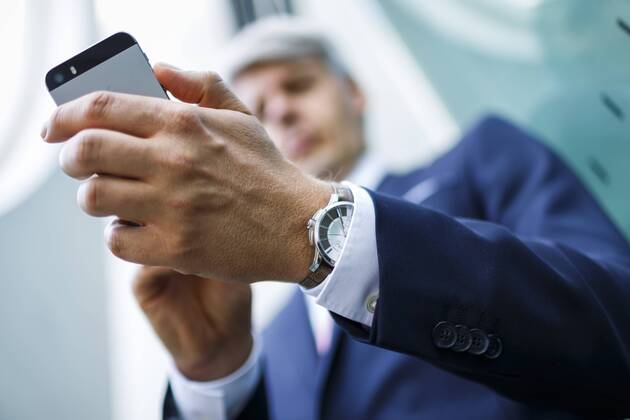 Ein Mann im Anzug haelt sein Smartphone Berlin, 07.08.2014. Model Released, Model Release vorhanden. Berlin Deutschland Copyright: xThomasxTrutschelx