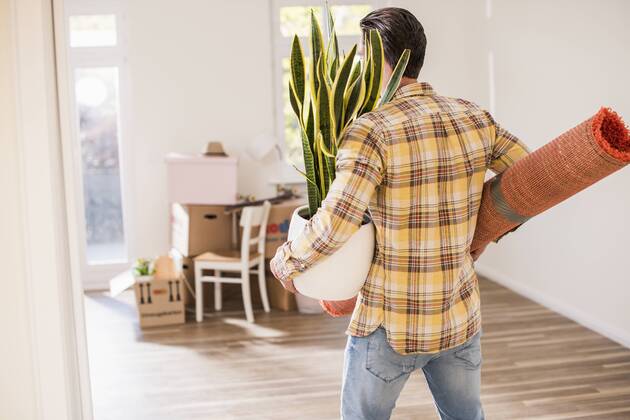 Young man carrying belongings in new home model released Symbolfoto property released  UUF10757