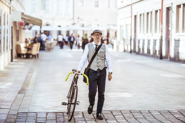 Mature businessman pushing bicycle in the city model released Symbolfoto  HAPF01781