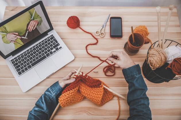 Knitting man using laptop for watching online tutorial, partial view model released Symbolfoto property released  RTBF00905