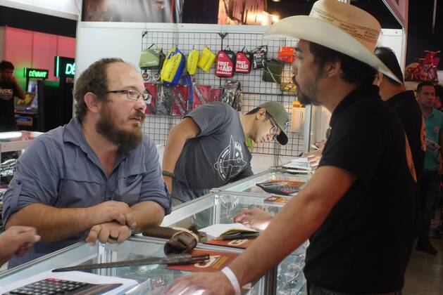 Philippines: HistoryCon 2017 A seller of bladed weapons and craftsmanship answering the inquiry of this potential buyer.  GeorgexBuid