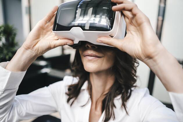 Businesswoman using VR goggles in office model released Symbolfoto property released KNSF02041