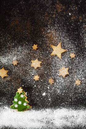 Christmas Cookies and icing sugar on baking tray  SBDF03273